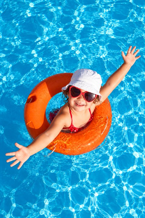 Kid floating in a pool with an inflatable ring